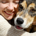 Woman hugs dog in close up. How to get a rescue dog.