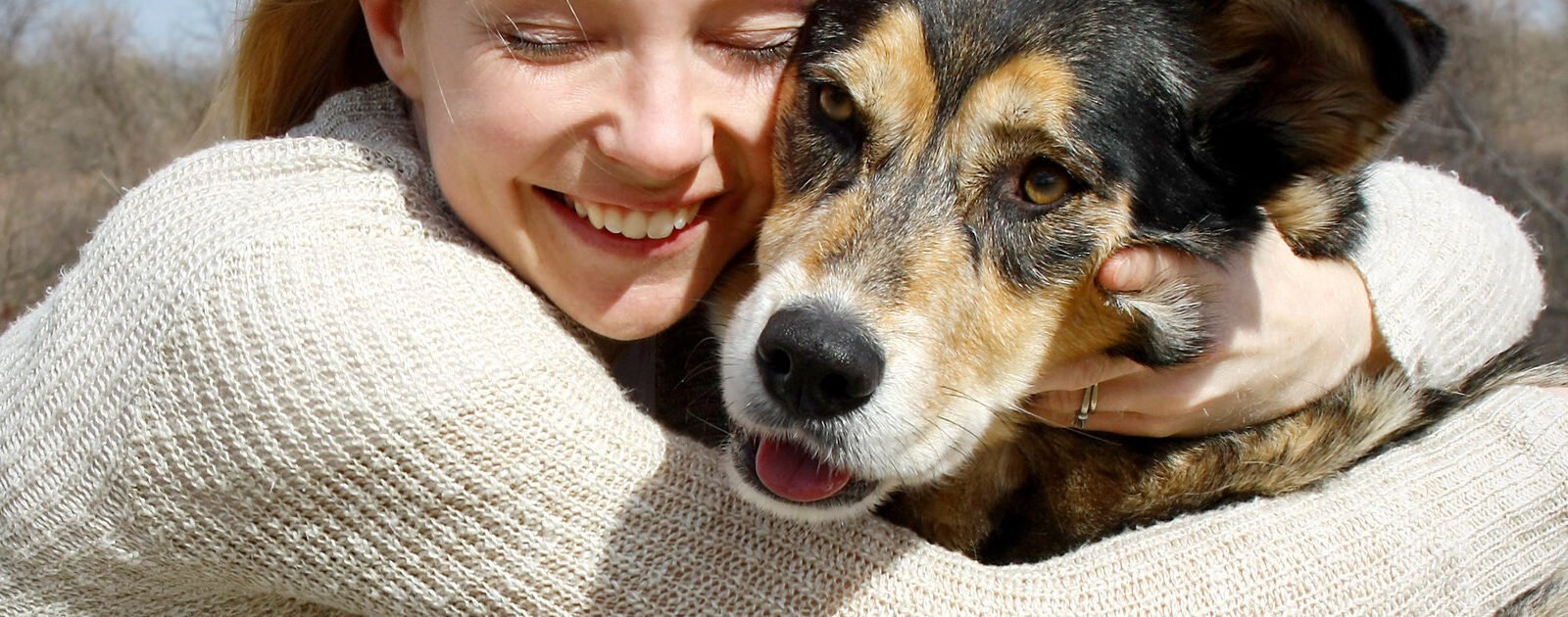 Woman hugs dog in close up. How to get a rescue dog.